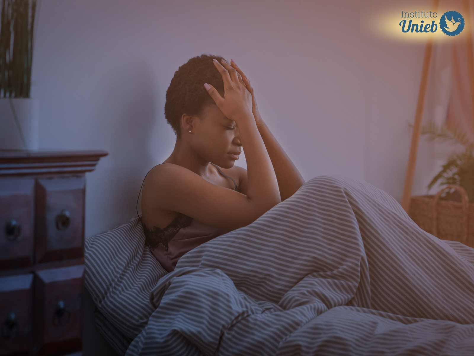 Mulher sentada na cama com as mãos na cabeça após acordar de um sonho ruim como um sonho com o ex-marido