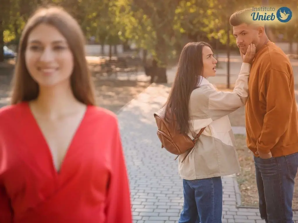 Casal brigando ao fundo porque homem está olhando para outra mulher na rua