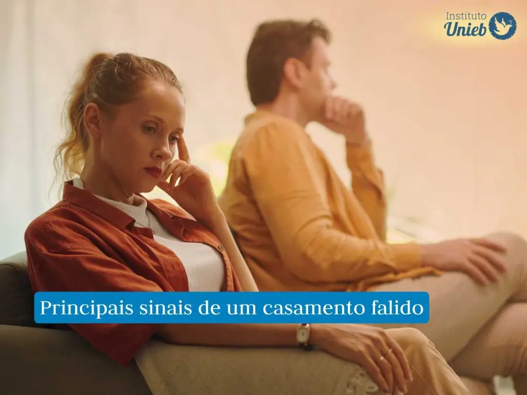 Homem e mulher sentados no sofá pensativos