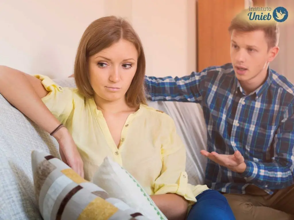 Homem e mulher sentados retratando um homem que critica sua parceira