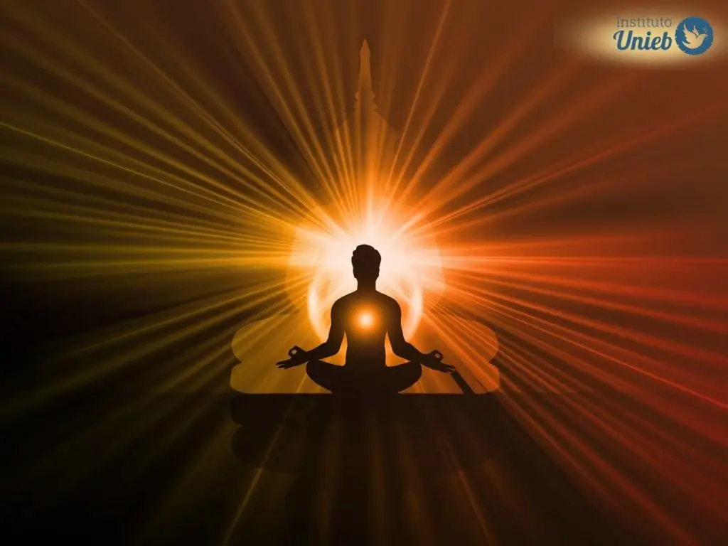 Silhueta humana em posição de meditação com luzes ao redor representando Entidades Espirituais