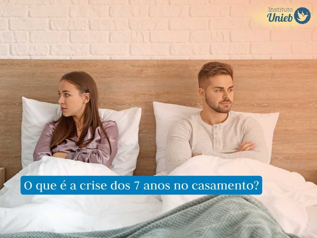 Casal sentado na cama em situação de briga simbolizando a crise dos 7 anos no casamento