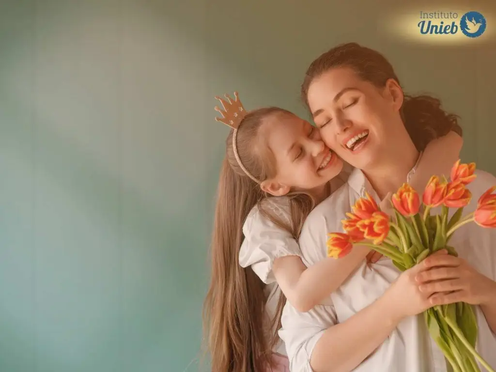 Mulher recebendo um buquê de flores e abraço da sua filha indicando uma celebração de Dia das Mães