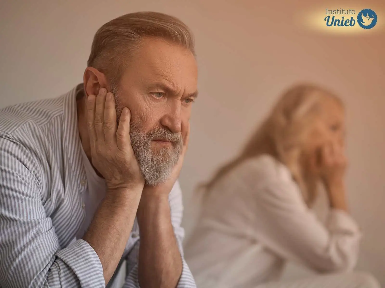 Homem e mulher sentados reflexivos representando um marido que quer se divorciar enquanto a esposa não quer o divórcio