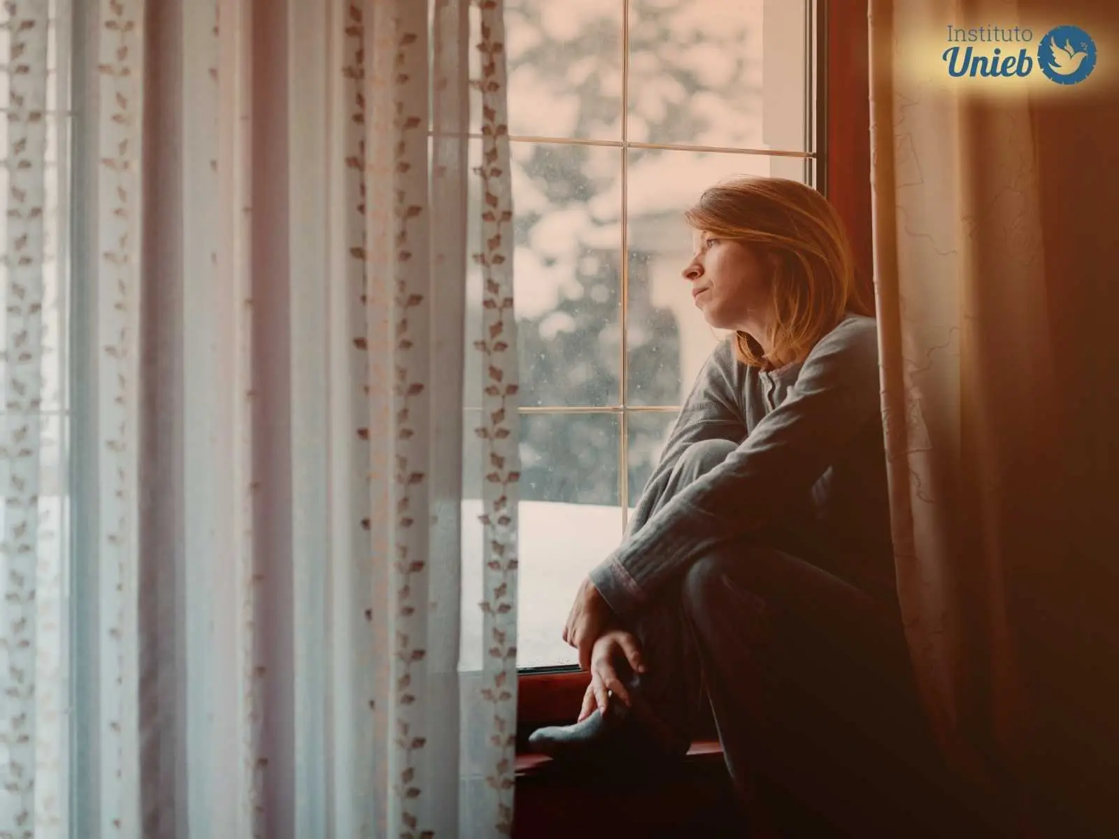 Blog Mulher olhando pela janela representando uma esposa que discutiu com o parceiro e olha pela janela esperando ele voltar após uma discussão