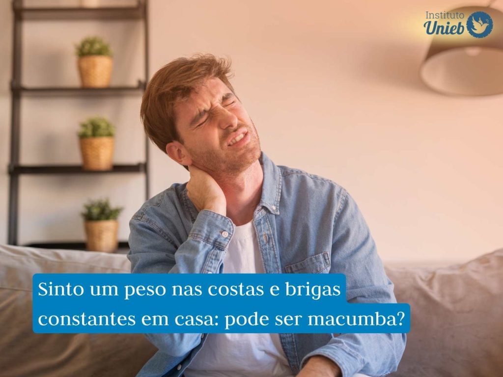 Homem sentado em sofá com as mãos no pescoço indicando uma pessoa que sente dor nas costas