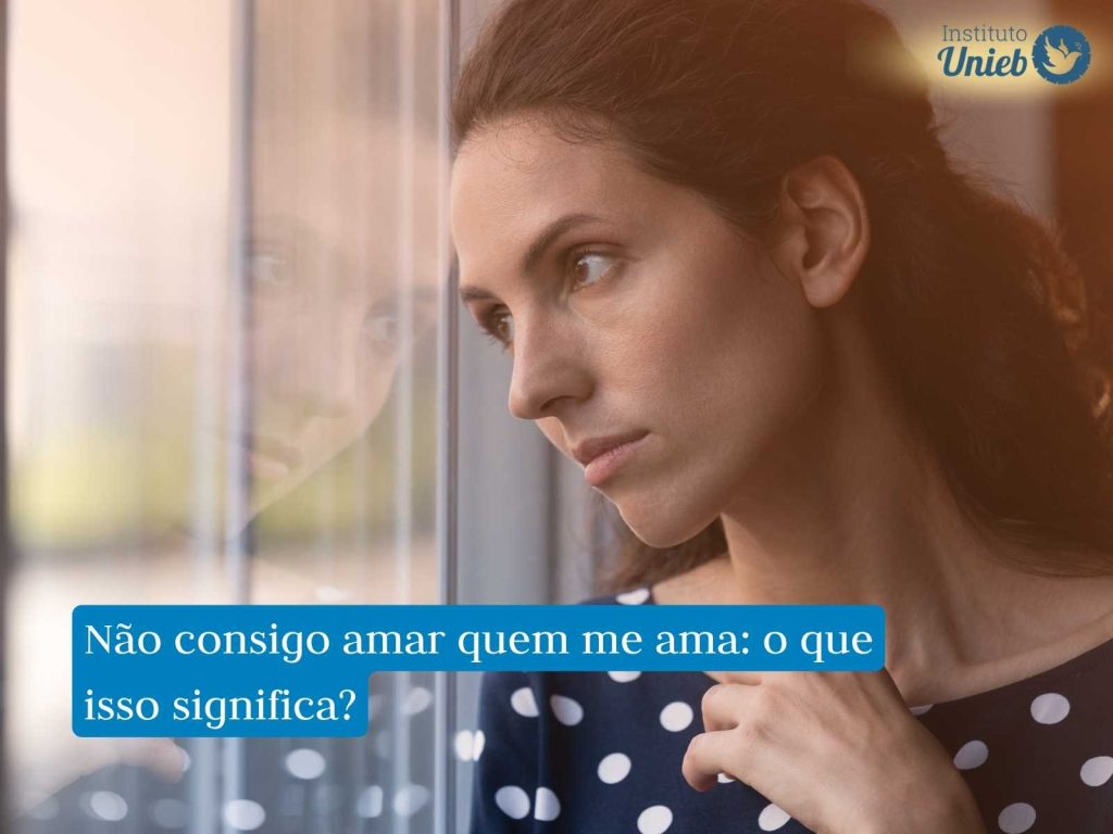 Por que não consigo amar quem me ama? Mulher olhando pela janela pensativa como quem reflete sobre não conseguir amar quem a ama