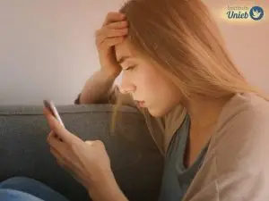 Mulher olhando o celular como quem compreende os sinais de que o parceiro não a ama mais