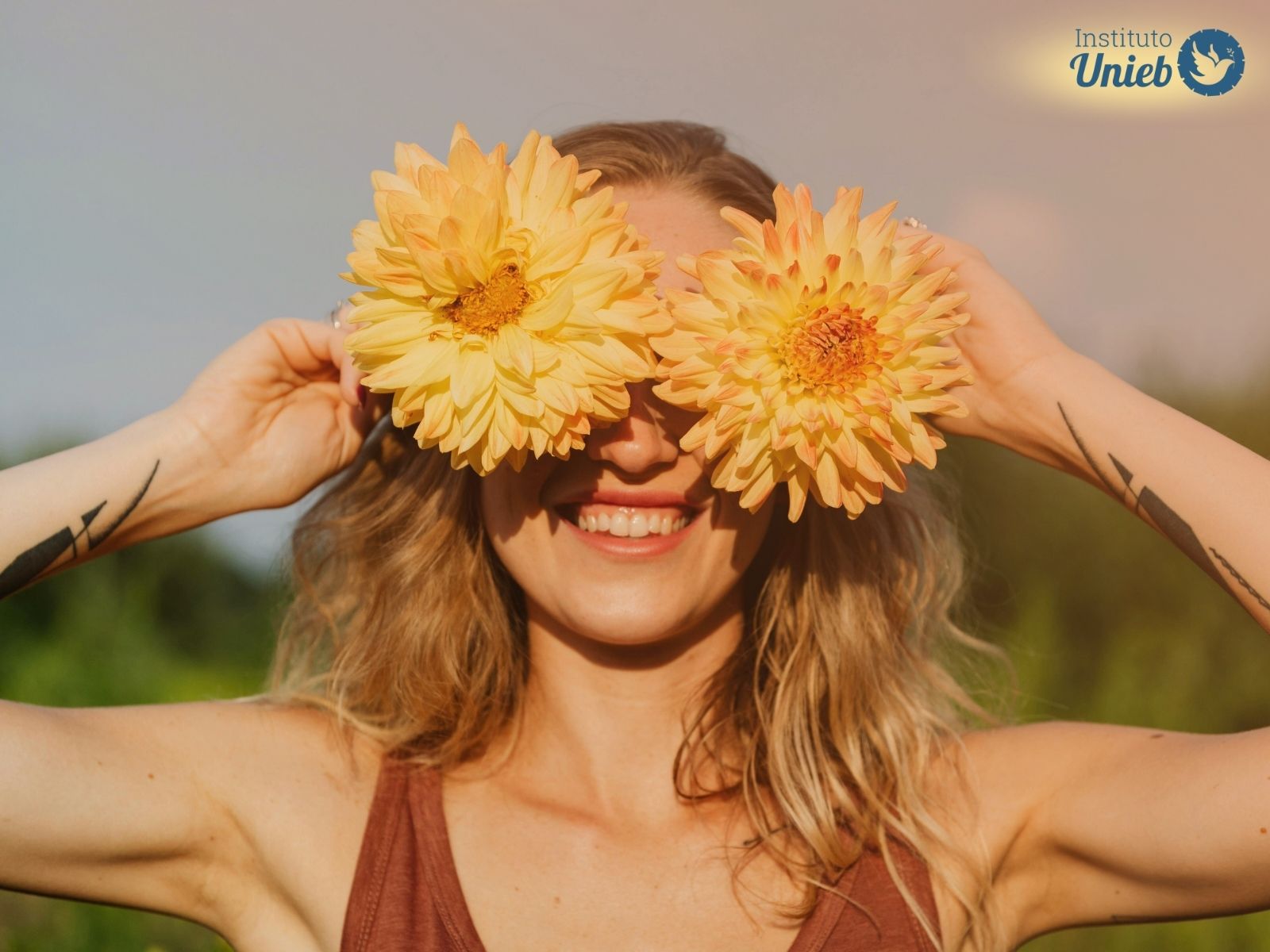 Mulher alegre com flores amarelas representando a energia de setembro e da primavera para novos começos amorosos
