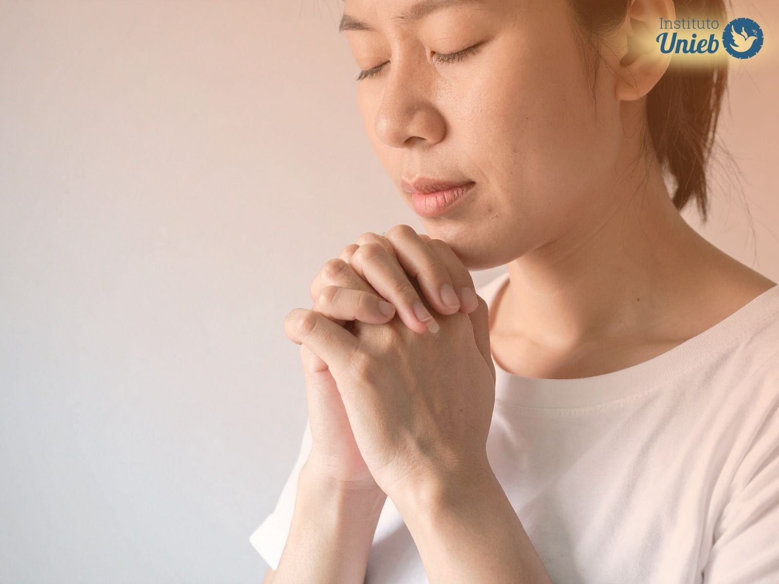 Mulher com mãos fechadas em prece representando alguém que pratica Rituais de Proteção Espiritual